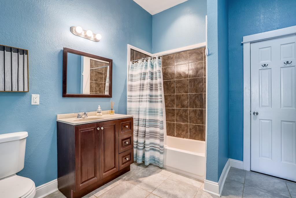 Your private bathroom features calming blue walls, a spacious tiled shower, and a polished vanity—everything you need to unwind after a day of exploring.