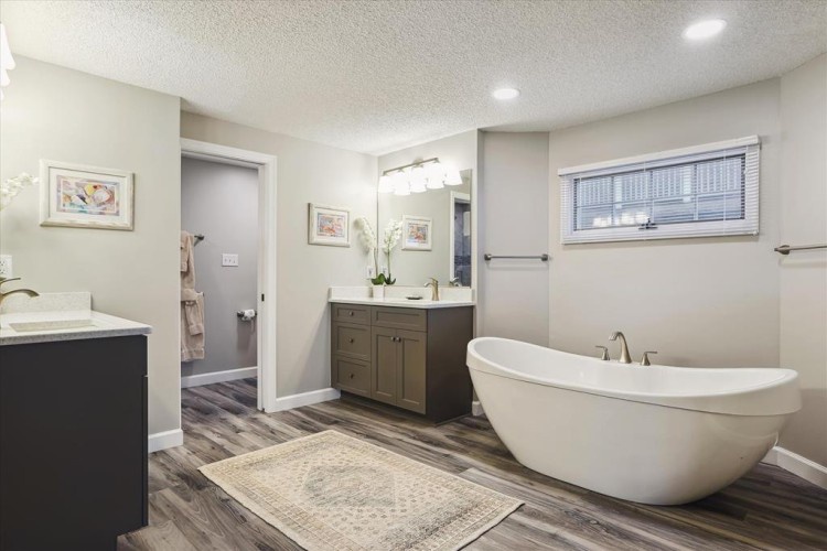 Unwind in your spa-like bathroom with a luxurious soaking tub, modern finishes, and elegant wood-look flooring—designed for ultimate relaxation during your stay.