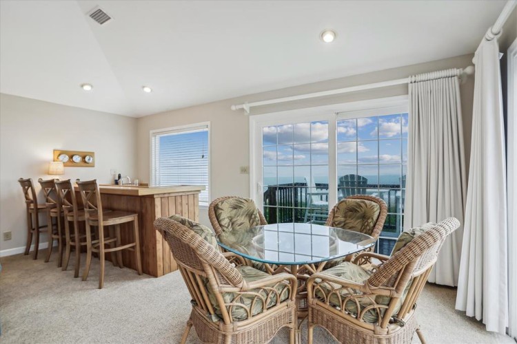 Your dining and conversation area opens to breathtaking water views, where casual meals and sunset conversations feel effortlessly special. Natural light floods the space, inviting you to unwind in comfort.