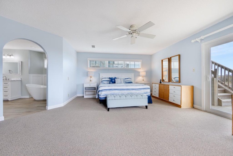 Your spacious master suite awaits with coastal elegance—relax in the airy comfort of plush carpets, a ceiling fan, an ensuite bath, and sliding doors opening to your private balcony.