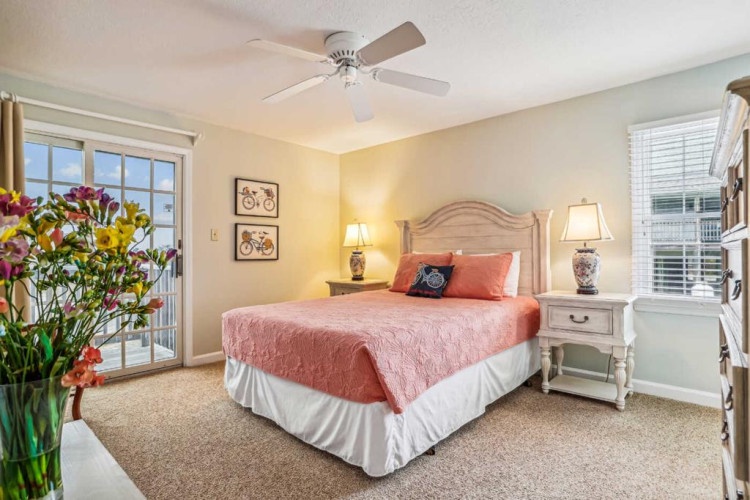 Relax in your serene bedroom with soft lighting, charming decor, and a ceiling fan to keep you comfortable. French doors open to natural light, making your stay feel bright and welcoming.