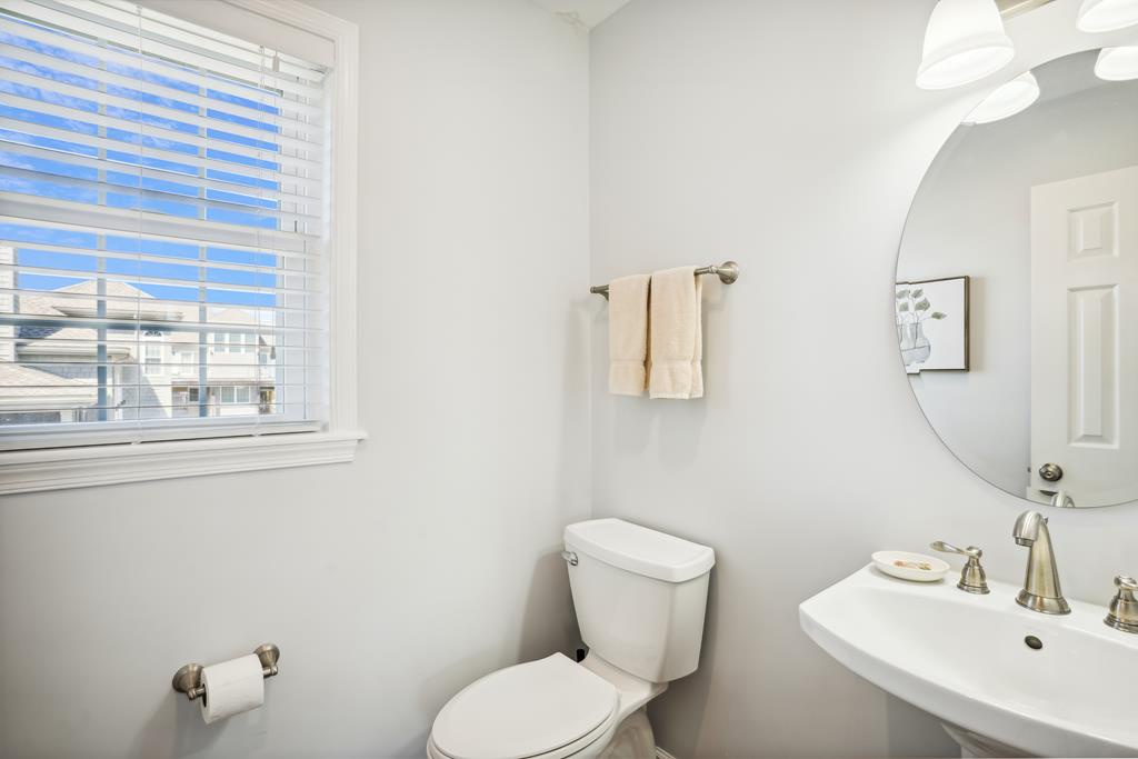 Freshen up in this bright, beautifully appointed bathroom with modern fixtures, crisp towels, and abundant natural light filtering through the window.