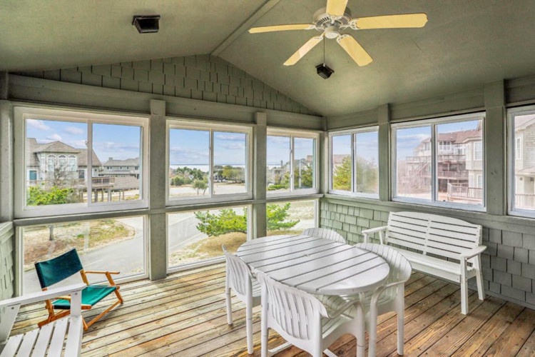 Relax in your private screened porch with ceiling fan and coastal views, perfect for morning coffee or evening gatherings surrounded by natural light and breezy comfort.