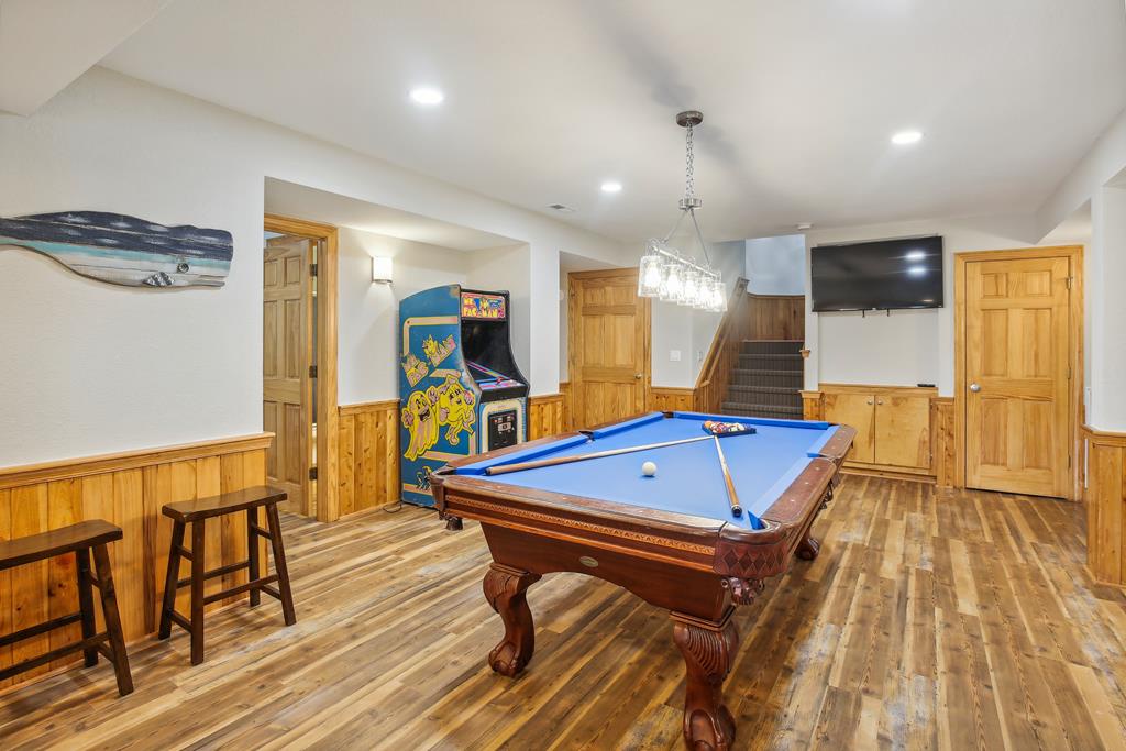 Challenge friends to pool or classic arcade games in this spacious entertainment room, complete with a big-screen TV and cozy seating—ideal for game nights and friendly competition.