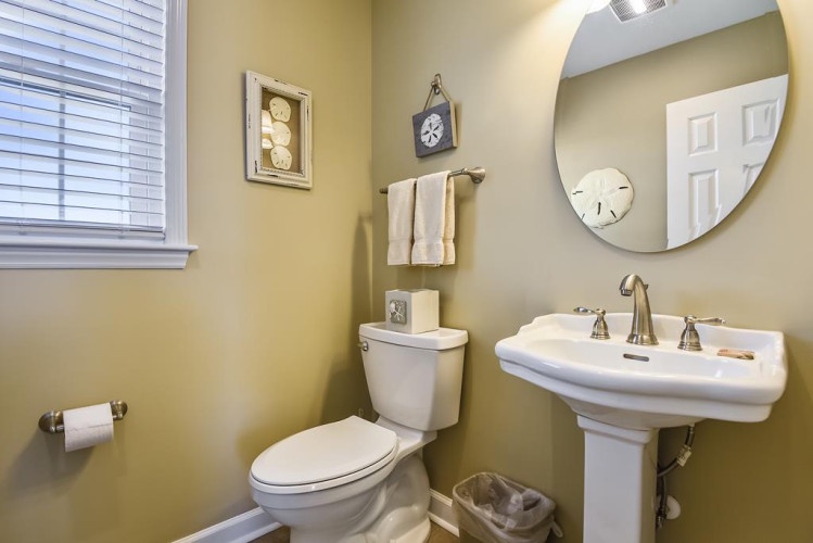 Step into your private bathroom with elegant pedestal sink, soft towels, and calming coastal touches—a peaceful space to refresh and unwind.