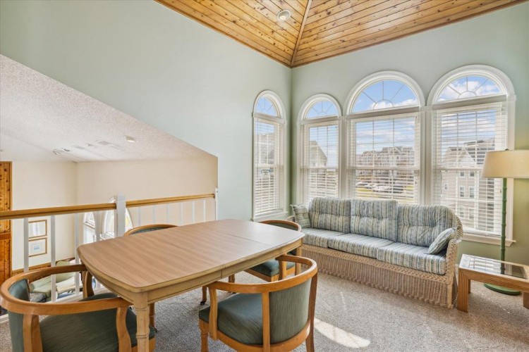 Relax under soaring wood-beamed ceilings in your bright, airy loft. Large arched windows flood the space with natural light while you unwind on the comfy sofa or gather around the dining table.