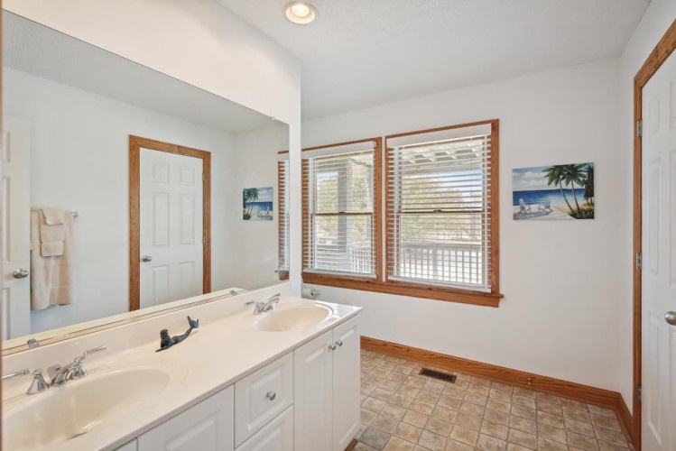 Freshen up in your private bathroom with dual sinks, a spacious vanity, and plenty of natural light streaming through the windows.