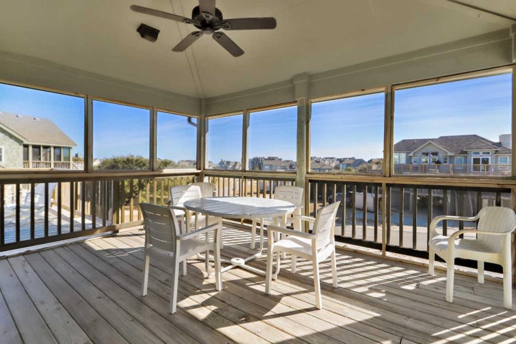 Picture yourself enjoying morning coffee or evening meals at this waterfront screened porch, where gentle breezes and panoramic water views create your perfect retreat.