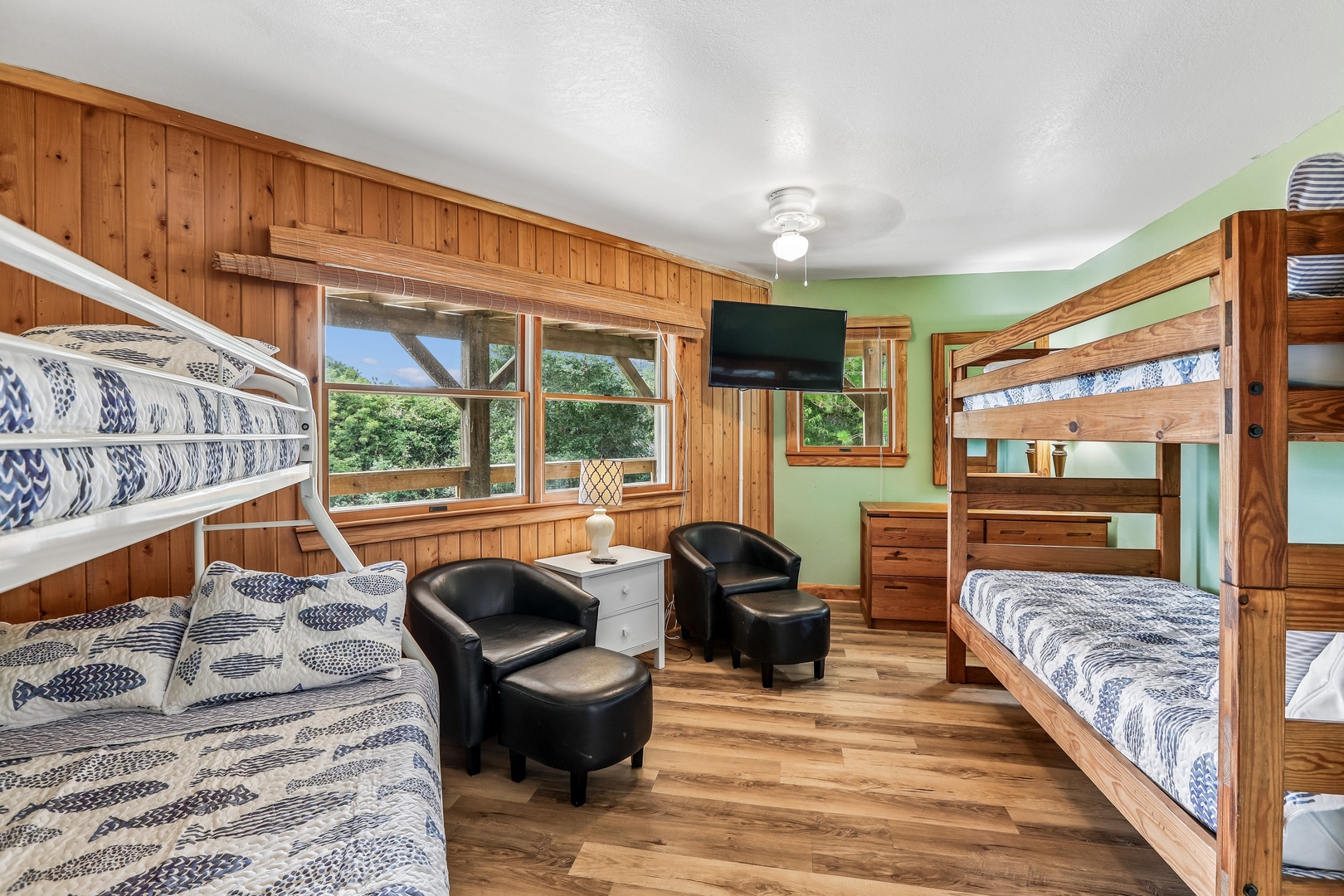 Your cozy bunk room welcomes everyone with warm wood tones, cheerful patterned bedding, and plenty of sleeping space. Curl up in the comfy chairs or enjoy greenery views through bright windows.