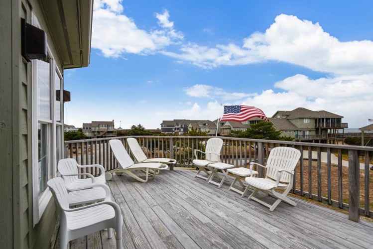 Soak up the sunshine from your private deck with comfortable loungers and Adirondack chairs, perfect for morning coffee or evening relaxation under open coastal skies.