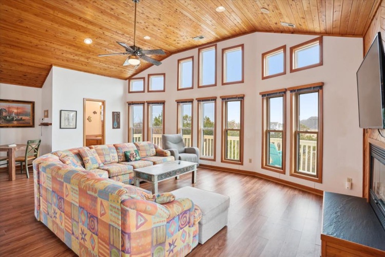 Picture yourself here, surrounded by soaring ceilings, warm wood, and walls of windows inviting natural light to flood your space. The open-concept design flows effortlessly—perfect for lazy mornings or evenings spent unwinding with your favorite people.