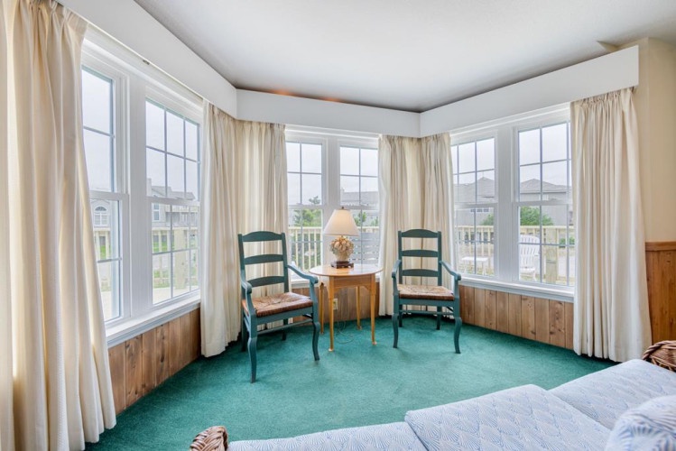 Settle into your private window nook with sweeping views of the neighborhood. Enjoy morning coffee or evening relaxation in one of the cozy chairs framed by soft curtains and natural light.