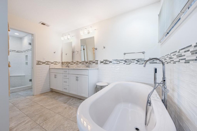 Step into your private spa-like retreat with a luxurious soaking tub, spacious double vanity, and elegant tile work that invites you to unwind in comfort.