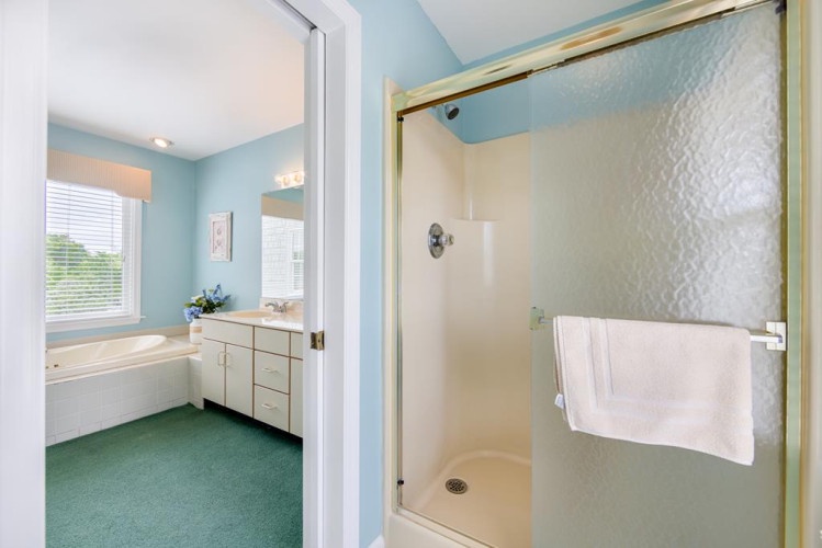 Your private bathroom awaits with a refreshing shower and soothing coastal-inspired blue tones, creating a serene retreat after your daily adventures.