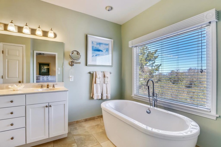 Slip into your soaking tub and unwind while natural light fills this serene spa-like bathroom, your personal retreat after exploring the area.