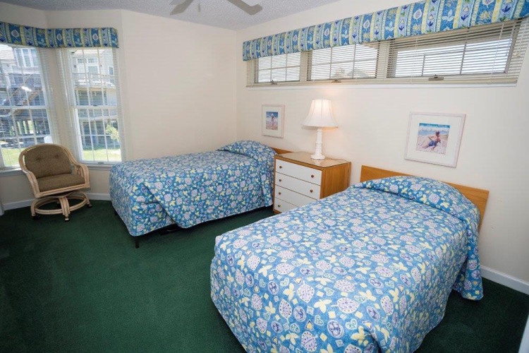 Settle into your cheerful beach-inspired bedroom, where two comfortable beds invite restful nights and sunny mornings. Natural light fills the space, creating a bright and welcoming retreat after your adventures.