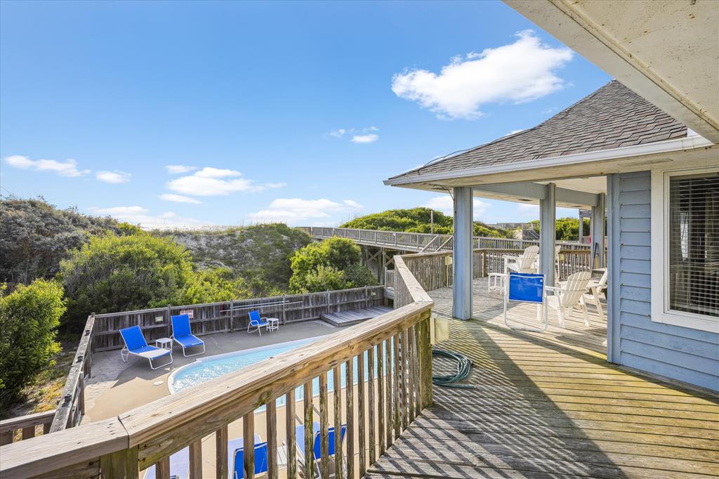 Elevated deck overlooking a private pool and lush coastal greenery, perfect for relaxing under open skies with comfortable seating and serene natural surroundings.