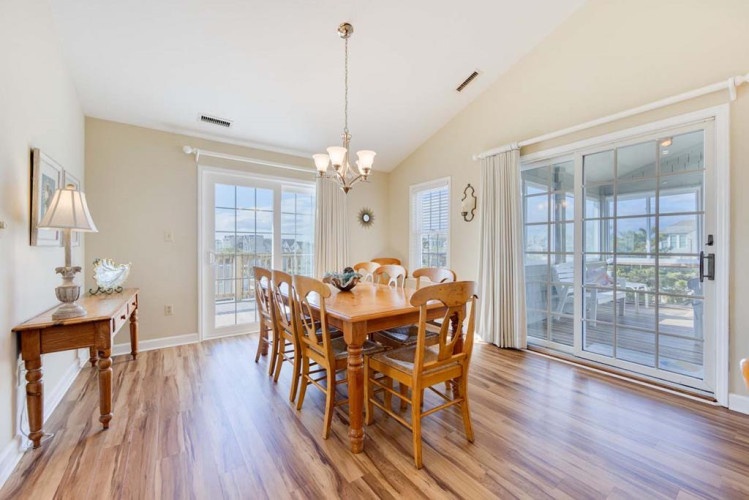 Gather around the warm wooden dining table where natural light pours through French doors, setting the perfect scene for morning coffee or evening meals with your loved ones.