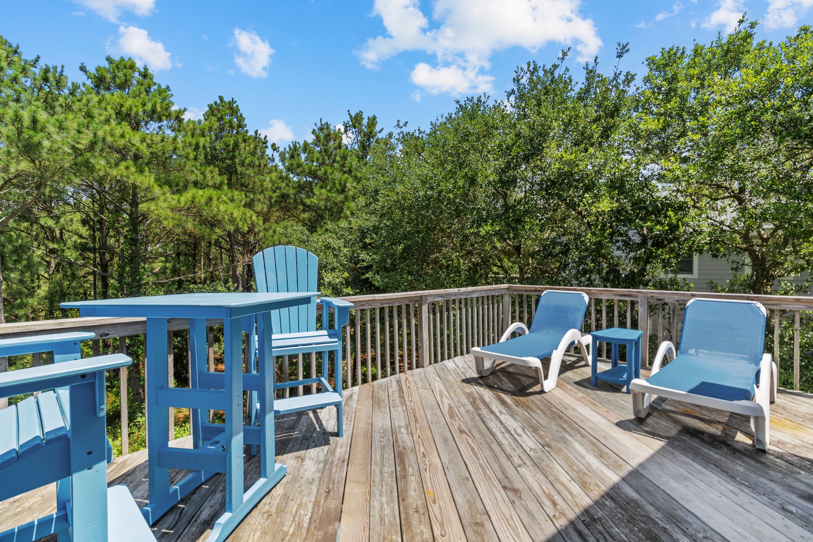 A spacious deck surrounded by lush greenery offers a peaceful escape where you can soak up the sun, breathe in fresh air, and unwind in your own private outdoor sanctuary.