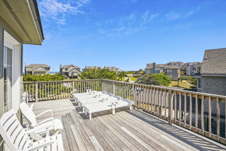Soak in warm sun and cool ocean breezes from your private deck, where white Adirondack chairs invite you to lounge with morning coffee or evening drinks while overlooking the neighborhood.