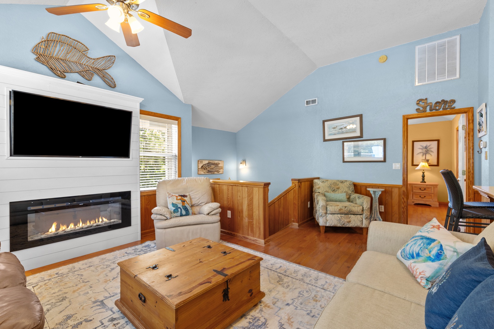 Unwind in this cozy coastal retreat with vaulted ceilings, a warm fireplace, and beach-themed touches. Sink into plush seating, enjoy your favorite shows, and let the ceiling fan keep you cool while you relax.