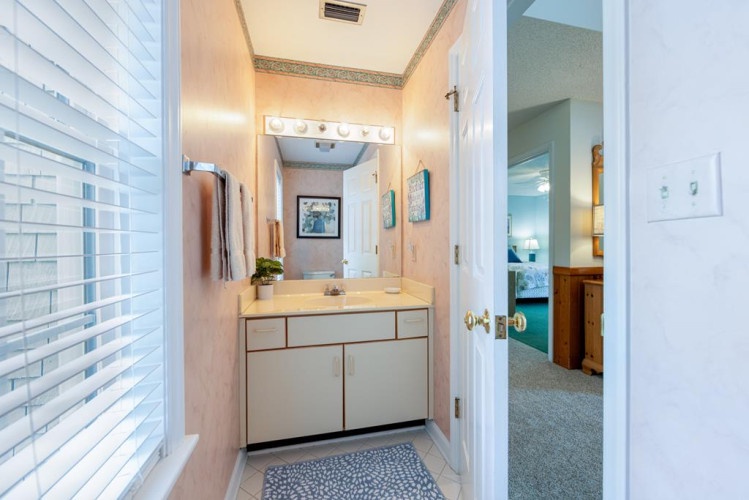 Your private bathroom features a well-lit vanity, fresh towels, and thoughtful touches like decorative tile work to make your stay comfortable and refreshing.
