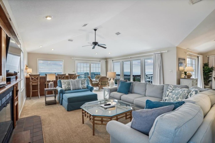 Picture yourself unwinding in this bright, spacious living and dining area with soothing coastal tones and an open layout. Floor-to-ceiling windows frame breathtaking ocean views, inviting natural light throughout your stay.