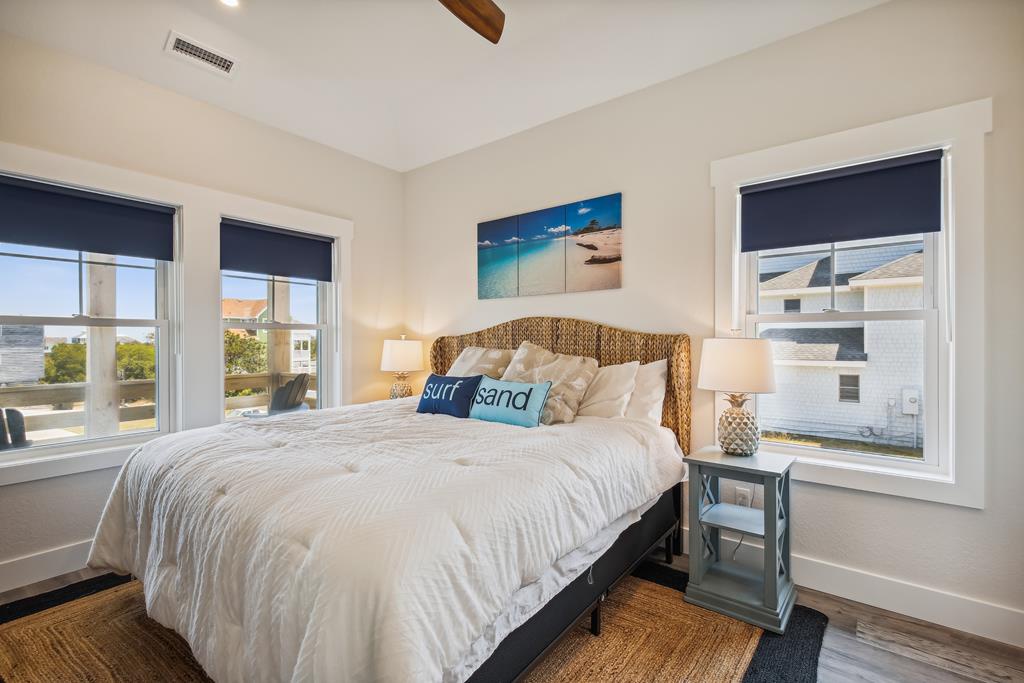 Drift off to sleep in this bright, beach-inspired bedroom. Soft linens, coastal decor, and pineapple-themed lamps create a relaxing retreat after a day exploring the shore.