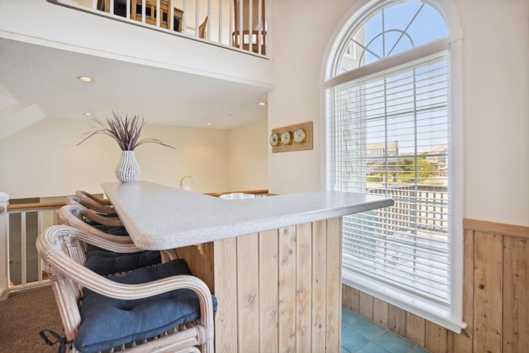 Enjoy morning coffee at this bright breakfast bar, where natural light pours through stunning arched windows and open sightlines create an airy, welcoming vibe.