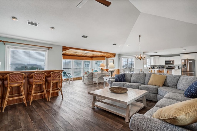 Step into your spacious open-concept retreat, where vaulted ceilings and natural light create a warm, inviting atmosphere. Relax on plush seating or gather at the breakfast bar for easy coastal living.