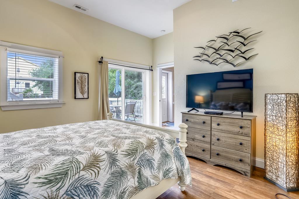 Drift off in your serene bedroom with soft natural light, tropical-print bedding, and a flatscreen TV. Wake to views of the patio through glass doors that open to outdoor relaxation.