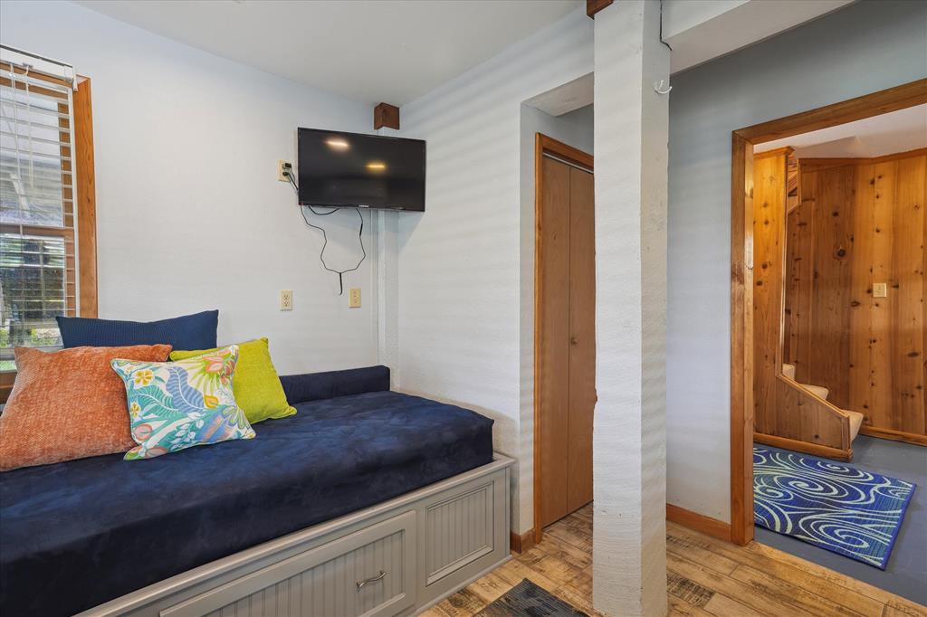 Your bright, welcoming bedroom features a comfortable day bed with colorful pillows and your own wall-mounted TV—perfect for relaxing after exploring the area.