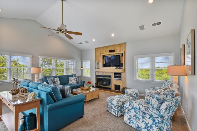 Your spacious living room features vaulted ceilings, a cozy fireplace, and plenty of natural light streaming through large windows—perfect for unwinding after a day of adventure.