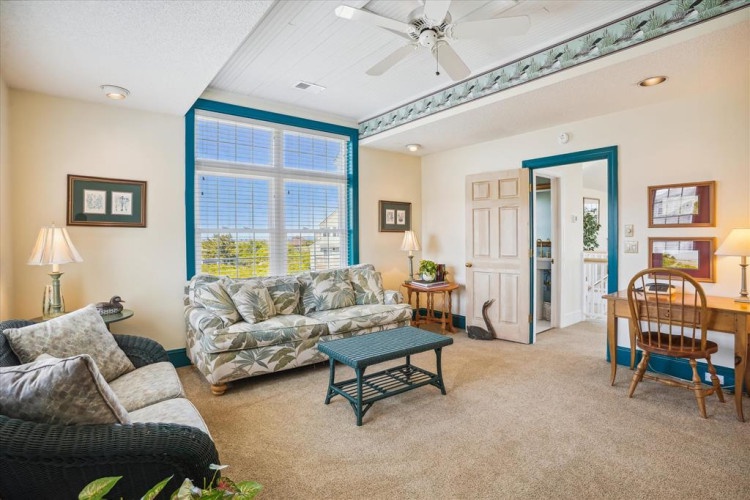 Settle into your bright and inviting living space with coastal-themed décor and a cozy seating arrangement. Large windows frame sunny views, while ceiling fans keep you comfortable year-round.