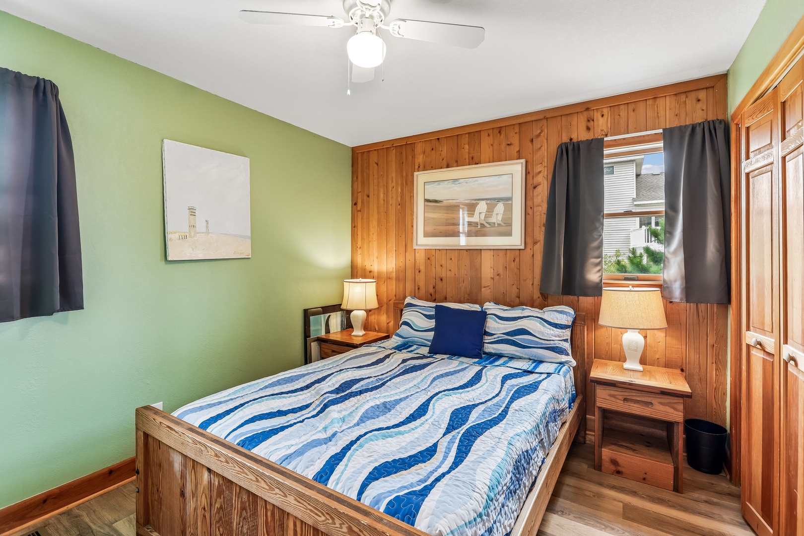Unwind in your cozy bedroom with warm wood paneling, soothing coastal touches, and a ceiling fan to keep you comfortable after a day of adventure.