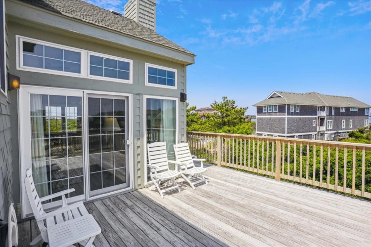A spacious wood deck overlooks nearby homes and greenery—your perfect spot to unwind with morning coffee or watch the sunset with a glass of wine.