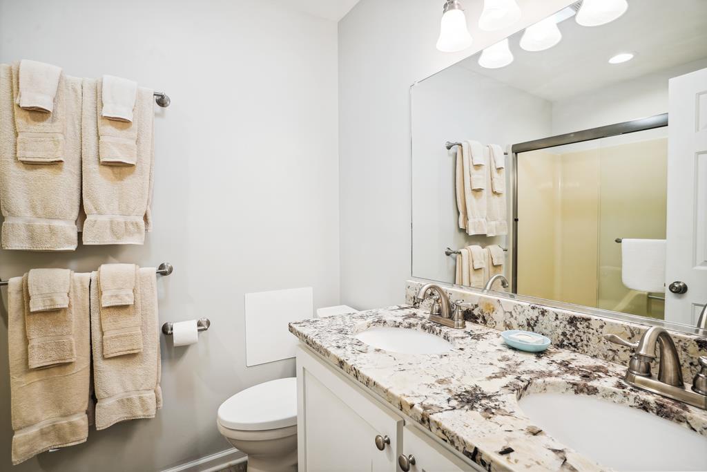 Your private bathroom features dual vanities with elegant granite countertops, plush towels, and bright modern lighting for your comfort and convenience.