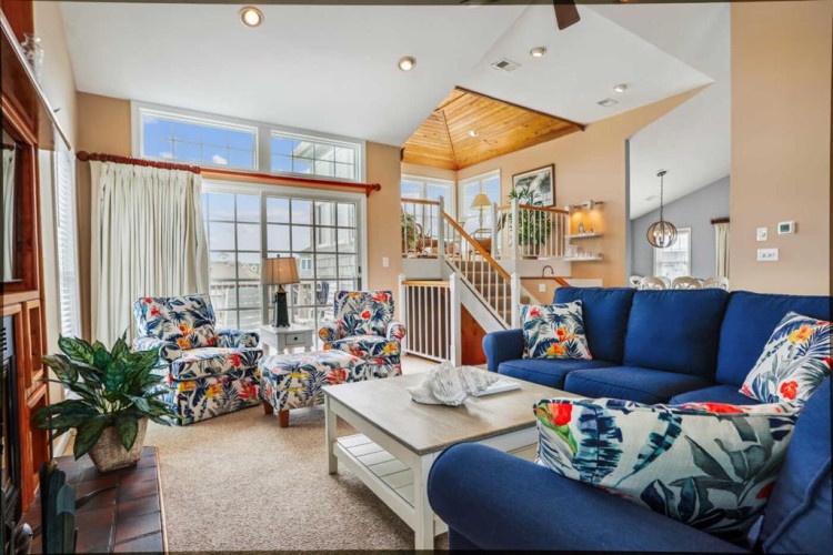 Step into your spacious living room where vibrant furnishings and soaring ceilings create an inviting retreat. Relax on plush seating, enjoy natural light from floor-to-ceiling windows, and unwind in a home designed for comfort.