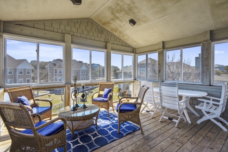 Relax in your screened porch with wicker seating, coastal views, and fresh air—perfect for morning coffee or unwinding after a day at the beach.