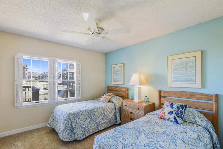 Drift off to sleep in this cheerful twin bedroom, where coastal blues meet soft yellows and natural light pours through plantation shutters. Wake up refreshed, ready to explore your beachside getaway.