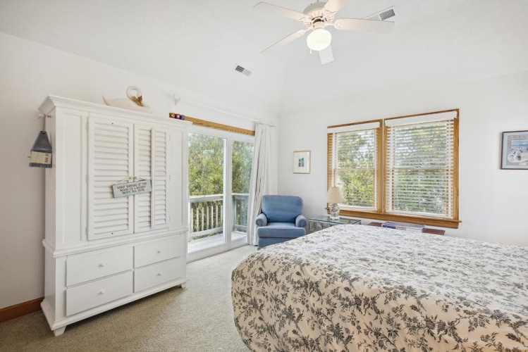 Relax in your serene bedroom where natural light pours through plantation-shuttered doors and windows, offering peaceful garden views. A cozy reading chair awaits your morning coffee.