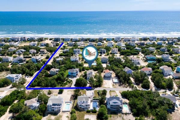 Aerial perspective showcasing a coastal residential neighborhood with direct beach access, just a short walk from the ocean's edge and sandy shores.