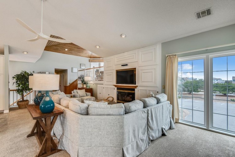 Step into your bright, airy living space with soaring ceilings and cozy seating arranged for relaxation. Sliding doors open to your private waterfront view—perfect for morning coffee or unwinding after a day of adventure.