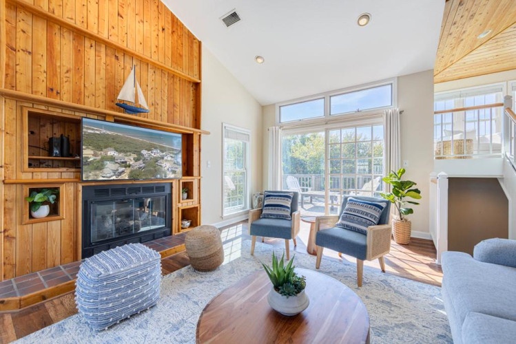Relax in this bright living space where sunlight streams through floor-to-ceiling windows, warming the wood floors and inviting you to curl up by the fireplace with a good book.
