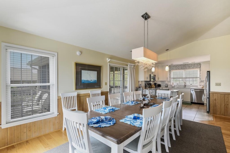Imagine gathering your group around this spacious table, where everyone has a seat and the open-plan design lets conversation flow easily between dining and kitchen. Bright windows frame your coastal retreat perfectly.
