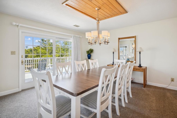 Gather around this inviting dining table where your group can share meals beneath natural light streaming through doors that open to your private balcony.