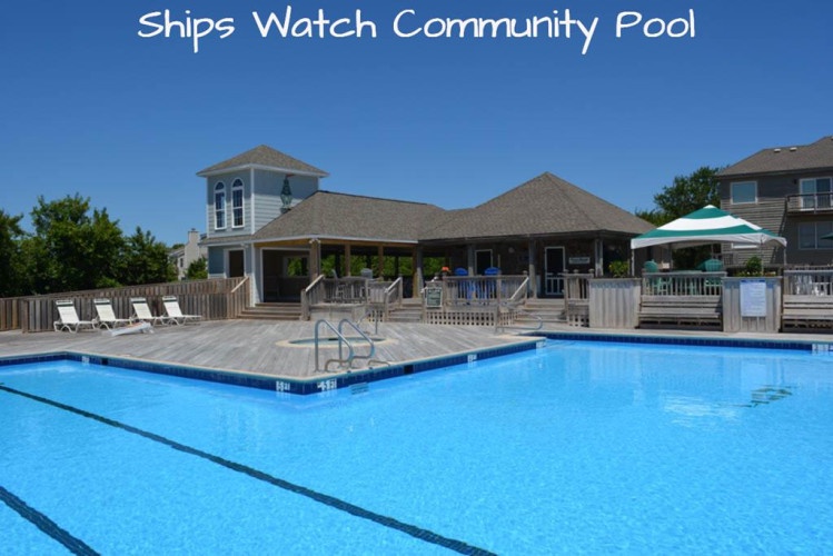 The Ships Watch Community Pool features a sparkling outdoor pool with swim lanes, surrounded by wooden decking and lounge chairs for soaking up the sun.