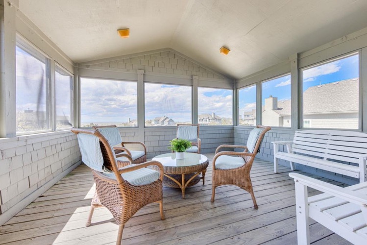 Relax in your private screened porch with panoramic water views, where comfortable wicker seating invites you to unwind with morning coffee or evening conversation.