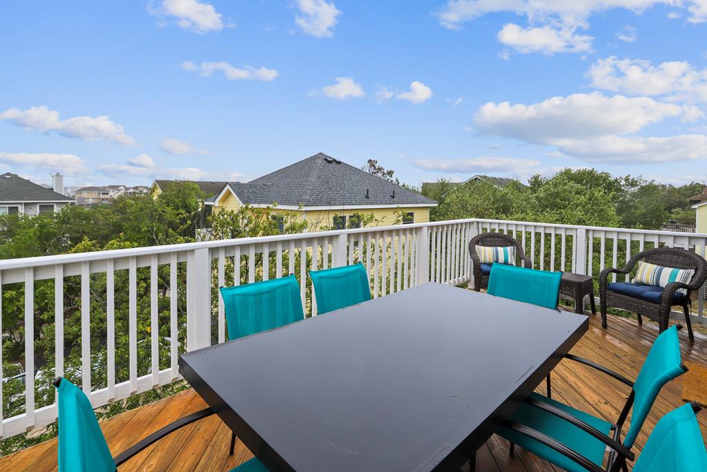 Elevated deck overlooking a quiet residential neighborhood, perfect for enjoying outdoor meals and relaxing under open skies. Comfortable seating awaits your morning coffee or evening gatherings.