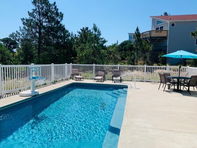 The sparkling pool awaits your arrival, surrounded by comfortable lounge chairs and dining space perfect for sunny afternoons. Dive in, relax poolside, and soak up the coastal atmosphere.